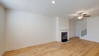 Located at 1801 Hamilton Rd in LaGrange, Georgia, this two-story home offers three bedrooms and three bathrooms across a well-designed layout. The main level is anchored by an open-concept kitchen and living area, where warm light wood-look flooring and crisp white walls create a clean, modern aesthetic. The kitchen features white shaker cabinetry, granite countertops, a center island with a sink, and stainless steel appliances. The adjoining living room is highlighted by a sleek fireplace with a white surround and a ceiling fan overhead. The upper level houses the generously sized primary bedroom, which features a tray ceiling, ceiling fan, and multiple windows that allow natural light to fill the space. The primary bathroom is well-appointed with a dual-sink granite vanity, a soaking tub, and a separate glass-enclosed shower, all finished with light wood-look flooring. Additional bedrooms are bright and comfortable, each with windows providing natural light. A walk-in closet with wire shelving adds practical storage. The attached garage offers ample space with an automatic opener. Throughout the home, consistent light hardwood flooring, recessed lighting, and neutral tones contribute to a cohesive and contemporary atmosphere.