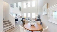 Located at 2115 Palmer Rd in Davenport, FL, this thoughtfully designed three-story home offers a well-organized layout across its floors, beginning with a garage and entry level at the base and living spaces that build upward. The dramatic heart of the home is the open-plan kitchen, dining, and living area, distinguished by soaring double-height ceilings and an abundance of windows that flood the space with natural light. A ceiling fan anchors the living room, while the kitchen impresses with white shaker cabinetry, granite countertops, a subway tile backsplash, and a full suite of stainless steel appliances. Wood-look flooring flows through the main living areas, complemented by clean white walls and modern recessed lighting throughout. A wide hallway connects rooms with an airy, welcoming feel. The two bedrooms offer plush carpet, ceiling fans, and natural light, with the primary bedroom providing a comfortable and well-proportioned retreat. Six bathrooms are finished with granite vanities and shaker-style cabinetry. A dedicated office provides a quiet, carpeted workspace with a window view. The in-unit laundry room includes a full-size washer and dryer. Four closets and three stairways add further functionality to this smartly planned multi-level home.