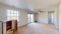 Located at 6801 Bordeaux Ct in Reynoldsburg, Ohio, this single-floor residence offers two bedrooms, two bathrooms, and a thoughtfully organized layout. The living room is a bright, open space anchored by a ceiling fan, a large window, and sliding glass doors that lead to a private balcony, filling the room with natural light and outdoor views. Plush carpet runs throughout the main living and bedroom areas, while durable wood-look flooring is found in the kitchen and bathrooms. The kitchen features white shaker-style cabinetry with matte black hardware, light granite-look countertops, and a black electric range, offering both style and functionality. The primary bedroom is a well-proportioned retreat with a walk-in closet equipped with wire shelving and hanging rods, and connects to a full bathroom featuring a soaking tub and shower combination. The second bedroom includes a large window that brings in natural light and comfortable carpet underfoot. A dedicated in-unit laundry room provides added convenience with overhead white cabinetry for storage. With four closets total throughout the home, storage is plentiful. Textured ceilings are found in select areas, and the neutral color palette creates a clean, cohesive feel throughout.