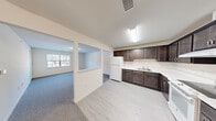 Located at 579 East Main Street in Middletown, NY, this one-bedroom, one-bathroom unit offers a well-organized and efficiently designed single-floor layout. The kitchen is a standout feature, showcasing rich dark espresso cabinetry with ample upper and lower storage, white quartz-style countertops, a tile backsplash, and white appliances including a refrigerator and electric range. Light wood-style flooring grounds the kitchen space, which flows openly toward the living room. The living room is carpeted and bright, benefiting from a large window that invites natural light and provides views of the surrounding area. The generously sized bedroom features soft carpet flooring, neutral walls, and a window offering outdoor views, creating a calm and comfortable retreat. A dedicated walk-in closet off the bedroom is outfitted with built-in wire shelving and hanging rods, providing substantial storage capacity. The bathroom is clean and functional, finished with tile flooring, a vanity with dark cabinetry, a toilet, and a glass-door shower enclosure. Throughout the unit, neutral tones and clean finishes create a cohesive, move-in-ready aesthetic suited for comfortable everyday living.