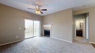 Located at 2525 River Oaks Dr in Columbus, OH, this 2-bedroom, 2-bathroom residence offers a well-designed single-floor layout with a thoughtful mix of comfort and functionality. The carpeted living room serves as the heart of the home, anchored by a tile-surround fireplace with a classic white mantel, a ceiling fan with integrated lighting, and a sliding glass door that opens to a private balcony with outdoor views — filling the space with natural light. The kitchen features dark cabinetry, a peninsula with an integrated sink, stainless steel refrigerator, electric range, and hardwood-style flooring that extends through the dining area. Both bedrooms are carpeted and include ceiling fans; the primary bedroom is generously sized with access to the balcony, while the secondary bedroom offers a large window for ample natural light. Five closets throughout the unit provide exceptional storage. The bathrooms are finished with wood-style flooring, dark vanities with stone countertops, and tiled tub-shower combos. A dedicated laundry room with a full-size washer and dryer and overhead shelving adds everyday convenience.