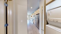 This well-designed one-bedroom, one-bathroom unit in Monona, WI offers a smart and functional layout across a single floor. Light-toned luxury vinyl plank flooring runs throughout, creating a cohesive and easy-to-maintain interior. The combined kitchen and living area forms the heart of the unit, where a galley-style kitchen impresses with light maple cabinetry, dark granite countertops, a white subway tile backsplash, and a full suite of stainless steel appliances including a refrigerator, range, microwave, and dishwasher. Recessed lighting keeps the kitchen bright and practical. The living area flows naturally toward floor-to-ceiling sliding glass doors that open onto a private balcony, flooding the space with natural light and providing pleasant outdoor views of the surrounding neighborhood. The bedroom is a cozy, well-proportioned retreat featuring a wall-mounted mini-split HVAC unit for personalized climate control and a ceiling fan for added comfort. A sliding barn-style door adds a modern touch to the room's entry. The bathroom is clean and contemporary, outfitted with a light maple vanity, dark granite countertop, a walk-in shower, and brushed nickel fixtures and towel bars throughout. The overall aesthetic is modern, minimal, and move-in ready.