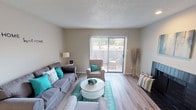 This single-story residence at 7500 Wicker Dr in Fort Worth, Texas offers a well-organized layout with neutral tones and functional finishes throughout. The living room serves as the heart of the home, featuring light wood-style flooring, a textured ceiling, and a sliding glass door flanked by vertical blinds that opens to a private outdoor patio, filling the space with natural light and providing outdoor views. A fireplace adds a practical focal point to the room.

The galley-style kitchen is efficiently designed with white cabinetry lining both sides, granite-style countertops, a double stainless steel sink, and wood-style flooring. Recessed lighting and a window keep the space bright, while ample cabinet storage maximizes functionality.

The bedroom features plush carpeting, a ceiling fan with light fixture, and a window with blinds that introduces natural light. The room offers generous wall space, creating flexibility for furniture arrangement.

The bathroom is well-appointed with a granite-style vanity countertop, a large mirror, white cabinetry for overhead storage, and a tub and shower combination with tiled surround. Wood-style flooring completes the space. Overall, the unit presents a cohesive, neutral aesthetic suitable for comfortable everyday living.