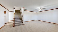 Located at 2518 Waterford Dr in Bowling Green, Kentucky, this two-story home offers a well-organized layout across four bedrooms, three bathrooms, and a single-car garage. The main floor provides a comfortable foundation, featuring a carpeted living room with crown molding, a ceiling fan, and a staircase with a classic wood banister leading to the upper level. The kitchen is outfitted with warm oak cabinetry, ample counter space, a double sink, a dishwasher, and tile flooring, with a window that brings in natural light. The main floor also includes a full bathroom with tile flooring, a vanity with wood cabinetry, and a soaking tub. The upper floor hosts the generously sized primary bedroom, along with additional bedrooms featuring vaulted ceilings and carpet flooring that allow natural light to filter in through windows. A walk-in closet with wire shelving provides practical storage. The bathrooms are consistently appointed with tile floors, wood vanities, and clean, neutral finishes. The attached garage features a concrete floor, an automatic opener, and attic access via a ceiling hatch. Throughout the home, rich wood trim, crown molding, and neutral walls create a cohesive and inviting atmosphere.
