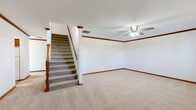 Located at 2518 Waterford Dr in Bowling Green, Kentucky, this two-story home offers a well-organized layout across four bedrooms, three bathrooms, and a single-car garage. The main floor provides a comfortable foundation, featuring a carpeted living room with crown molding, a ceiling fan, and a staircase with a classic wood banister leading to the upper level. The kitchen is outfitted with warm oak cabinetry, ample counter space, a double sink, a dishwasher, and tile flooring, with a window that brings in natural light. The main floor also includes a full bathroom with tile flooring, a vanity with wood cabinetry, and a soaking tub. The upper floor hosts the generously sized primary bedroom, along with additional bedrooms featuring vaulted ceilings and carpet flooring that allow natural light to filter in through windows. A walk-in closet with wire shelving provides practical storage. The bathrooms are consistently appointed with tile floors, wood vanities, and clean, neutral finishes. The attached garage features a concrete floor, an automatic opener, and attic access via a ceiling hatch. Throughout the home, rich wood trim, crown molding, and neutral walls create a cohesive and inviting atmosphere.