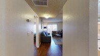 Located at 6942 E Rosewood St in Tucson, Arizona, this single-floor unit offers a well-organized layout with consistent hardwood-style flooring throughout. The living area serves as the heart of the space, featuring a textured ceiling, a striking white brick accent wall, and a sliding glass door that opens to an outdoor patio, allowing natural light to fill the room. The kitchen is outfitted with white cabinetry, a brick-tile backsplash, laminate countertops, and white appliances including a range, dishwasher, and refrigerator. A dedicated nook within the kitchen provides additional utility space with a window for natural ventilation. The unit includes multiple bedrooms, each with hardwood-style flooring, textured ceilings, and vertical blinds on the windows. The primary bedroom is generously proportioned and features an expansive set of bi-fold closet doors offering substantial storage capacity. A secondary bedroom includes its own closet and window. Throughout the unit, neutral wall tones create a calm, cohesive atmosphere. The single-floor layout ensures easy accessibility and efficient use of space, making this Tucson residence a practical and comfortable option.
