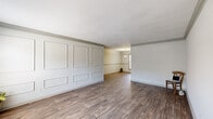 Located at 2809 Clairmont Rd NE in Brookhaven, GA, this single-story home offers a well-organized layout comprising three bedrooms, two bathrooms, a living room, kitchen, and connecting hallway. The living area is a standout feature, showcasing a decorative wall panel treatment with framed molding detail, complemented by wood-look flooring that extends throughout the main living spaces. The open sight line from the living room into an adjacent area, accented by a pendant light and natural window light, gives the home a connected, airy feel.

The primary bedroom is generously proportioned and features carpet flooring and a ceiling fan with light fixture. The additional bedrooms also include carpet flooring, ceiling fans, and windows that allow natural light. The kitchen is equipped with dark cabinetry, stainless steel appliances including a refrigerator, range, and microwave, along with light countertops and wood-look flooring.

Both bathrooms feature subway tile walling, dark-toned vanity cabinetry with framed mirrors, and wood-look flooring. One bathroom includes a tub-shower combination. Overall, the home presents a clean, neutral palette with consistent finishes throughout.