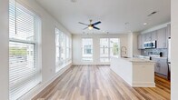 Located at 250 Arizona Ave NE in Atlanta's sought-after Inman Park neighborhood, this thoughtfully designed one-bedroom, one-bathroom residence offers a clean, contemporary aesthetic throughout its efficiently laid-out single floor. Light-toned hardwood flooring runs seamlessly across the entire space, complementing the crisp white walls and creating a bright, cohesive feel.

The open-concept kitchen and living area serves as the heart of the home. The kitchen is equipped with stainless steel appliances, including a range, microwave, and refrigerator, and is appointed with gray shaker-style cabinetry, a subway tile backsplash, white quartz countertops, and a central island with an undermount sink — ideal for both cooking and entertaining. Recessed lighting and a ceiling fan keep the living area well-lit and comfortable, while multiple large windows dressed with horizontal blinds allow generous natural light and neighborhood views.

The bedroom features corner and wall-spanning windows that flood the room with daylight and offer outdoor views, creating a bright and airy retreat. The bathroom continues the home's modern palette with matching gray cabinetry, stone countertops, and wood-look flooring. A charming panel-style entry door and a clean entryway hallway complete this well-appointed residence.