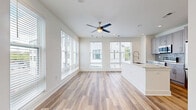 Located at 250 Arizona Ave NE in Atlanta's sought-after Inman Park neighborhood, this thoughtfully designed one-bedroom, one-bathroom residence offers a clean, contemporary aesthetic throughout its efficiently laid-out single floor. Light-toned hardwood flooring runs seamlessly across the entire space, complementing the crisp white walls and creating a bright, cohesive feel.

The open-concept kitchen and living area serves as the heart of the home. The kitchen is equipped with stainless steel appliances, including a range, microwave, and refrigerator, and is appointed with gray shaker-style cabinetry, a subway tile backsplash, white quartz countertops, and a central island with an undermount sink — ideal for both cooking and entertaining. Recessed lighting and a ceiling fan keep the living area well-lit and comfortable, while multiple large windows dressed with horizontal blinds allow generous natural light and neighborhood views.

The bedroom features corner and wall-spanning windows that flood the room with daylight and offer outdoor views, creating a bright and airy retreat. The bathroom continues the home's modern palette with matching gray cabinetry, stone countertops, and wood-look flooring. A charming panel-style entry door and a clean entryway hallway complete this well-appointed residence.