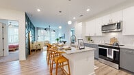 Located at 1170 Temple Dr in Sugar Hill, GA, this single-floor residence combines modern design with functional living. The open-concept layout seamlessly connects the kitchen, dining, and living areas, creating a bright and airy atmosphere enhanced by recessed lighting and wood-look flooring throughout.

The kitchen is a standout feature, outfitted with two-tone cabinetry — crisp white upper cabinets paired with gray lower cabinets — granite countertops, stainless steel appliances, a subway tile backsplash, and a center island with pendant lighting and bar seating. The living area is anchored by a striking geometric accent wall in sage green, adding a bold architectural element to the space.

The bedrooms offer comfortable retreats, each with carpeted flooring, generous natural light from large windows with blinds, and ample closet space, including a walk-in closet with built-in wire shelving. The bathrooms are well-appointed with granite vanity countertops, gray cabinetry, large mirrors, and wood-look tile flooring. One bathroom features a soaking tub with built-in shelving, while another includes a walk-in shower. Clean white walls and modern fixtures throughout contribute to a cohesive, contemporary aesthetic.