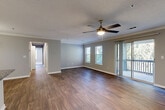 Located at University Station Circle in Charlotte, NC, this 2-bedroom, 2-bathroom residence offers a well-designed single-floor layout with a cohesive blend of comfort and functionality. The spacious living room is a highlight, featuring rich hardwood-style flooring, crown molding, a ceiling fan with light fixture, and sliding glass doors that open to a private balcony with outdoor views — allowing natural light to fill the space. The kitchen is thoughtfully designed in a galley style, outfitted with white shaker cabinetry, granite countertops, a tile backsplash, and a full suite of stainless steel appliances including a range, microwave, refrigerator, and dishwasher. The generously sized primary bedroom includes plush carpeting, a ceiling fan, large windows, and dual mirrored sliding-door closets offering ample storage. The second bedroom is equally comfortable, with soft carpeting and a bright window. Both bathrooms feature hardwood-style flooring, white cabinetry with granite countertops, and a tub/shower combination. Two hallways connect the rooms efficiently throughout the layout. The space presents a clean, neutral palette throughout, making it move-in ready and highly adaptable to any aesthetic.