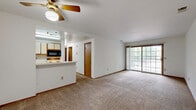 Located at 322 Cobb Run Ln in Clayton, Ohio, this two-bedroom, one-bathroom single-story home offers a straightforward and functional layout designed for comfortable everyday living. The living room provides a generous open area with neutral carpet flooring, white walls, and a ceiling fan with a built-in light fixture, creating a bright and airy atmosphere. A front entry door leads directly into this space, making it welcoming and accessible. The galley-style kitchen is efficiently designed with wood-look vinyl flooring, white cabinetry with wood-trim accents, ample counter space, a double sink, and black appliances including a refrigerator, microwave, and electric range, along with a dishwasher. The full bathroom features wood-look vinyl flooring, a vanity with a large mirror, and a full tub-shower combo. Both bedrooms are carpeted and include wood-trimmed doors; the primary bedroom benefits from two windows that bring in natural light, while the second bedroom includes a sliding closet. A dedicated laundry area and hallway complete the home's practical floor plan, offering efficient use of the available space throughout.