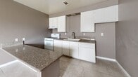 Located at 12035 White Ave in Adelanto, California, this single-story, 2-bedroom, 1-bathroom home offers a practical and comfortable layout finished with consistent tile flooring throughout. The open-concept living, dining, and kitchen area forms the heart of the home, creating a connected and functional space. The kitchen is well-equipped with white cabinetry, granite-look countertops, a gas range, and a built-in sink, complemented by a peninsula that adds additional prep and dining space. A built-in cabinet nook along the adjacent wall provides additional storage. The textured ceilings and warm taupe-toned walls carry through the common areas, giving the space a cohesive look. Both bedrooms feature neutral gray walls, large windows with vertical blinds that invite natural light, and sliding-door closets for convenient storage. The primary bedroom offers a comfortable footprint ideal for standard furnishings. The shared full bathroom includes a tub-shower combination, toilet, and a vanity with sink, finished in a clean, minimal style. A hallway connects the private areas of the home, and two closets provide ample storage throughout. The layout is efficient and straightforward, making this home well-suited for individuals or small households.