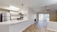 Located at 5412 Deerbrooke Creek Cir in Tampa, Florida, this single-story home offers a thoughtfully updated interior with a bright, cohesive design. The living room serves as the heart of the space, boasting soaring vaulted ceilings, a ceiling fan, and a tile-surround fireplace that adds warmth and character. Large sliding glass doors flood the room with natural light and provide direct access to an outdoor area, enhancing the open, airy feel. Wood-look flooring runs throughout, tying the spaces together seamlessly.

The kitchen has been renovated with crisp white shaker cabinetry, quartz countertops, a classic subway tile backsplash, and stainless steel appliances including an electric range with built-in microwave. A breakfast bar peninsula connects the kitchen to the living and dining areas, making it ideal for both everyday living and entertaining.

The bedrooms are generously proportioned, each featuring ceiling fans, large windows with blinds that invite natural light, and the same wood-look flooring found throughout the home. The bathrooms are finished with white cabinetry, quartz vanity tops, and clean tile work, including a full tub-shower combination. Overall, the home presents a clean, modern aesthetic in a well-established Tampa neighborhood.