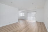 Located at 9404 Van Nuys Blvd in Los Angeles, CA, this thoughtfully designed 2-bedroom, 1-bathroom unit offers a clean, modern aesthetic across a single floor. Light wood-style flooring runs continuously throughout the space, complementing the crisp white walls and creating a bright, cohesive atmosphere.

The open living area is generously proportioned, featuring recessed lighting and large windows fitted with vertical blinds that invite abundant natural light. A sliding glass door in the living area further enhances the airy feel. A hallway connects the main living space to the private areas of the unit.

The primary bedroom is a comfortable, well-sized room, offering a ceiling fan, a window with exterior views, and easy access to a dedicated walk-in closet equipped with dual hanging rods — providing ample storage. The second bedroom mirrors the minimalist design, with white walls, matching flooring, and its own entry door.

The bathroom is clean and functional, featuring a full shower-tub combination with white surround walls, chrome fixtures, and a vanity with a bold blue cabinet base that adds a touch of color. Recessed lighting and a well-lit hallway complete the interior layout, making this a practical and inviting space throughout.