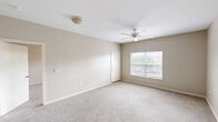 Located at 1702 Skinner St in Freeport, Texas, this two-story residence offers three bedrooms, two bathrooms, and a thoughtfully arranged floor plan spread across two levels. The main living areas occupy the upper floor, which comprises the bulk of the home's total footprint, while the entry level provides a transition into the space via staircase access.

The kitchen is well-equipped with a U-shaped layout featuring white cabinetry with wood-tone trim, light countertops, black appliances including a range, over-the-range microwave, refrigerator, and dishwasher, all set on light wood-style flooring. The bathrooms are finished with light wood-look flooring, white vanities, and a tub-shower combination with tiled surround.

Bedrooms are carpeted and finished in neutral tones, each fitted with ceiling fans and windows that bring in natural light and views of the surrounding community. The generous primary bedroom connects to a bathroom and features its own closet. Multiple walk-in and standard closets throughout provide ample storage, each equipped with wire shelving systems. A utility area includes washer/dryer hookups and a water heater. A private balcony overlooks the parking area and neighboring buildings, completing this functional and comfortable residence.