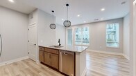 Located at 199 Dickenson St in Columbus, Ohio, this well-appointed one-bedroom, one-bathroom unit offers a thoughtfully designed open-concept layout with modern finishes throughout. The kitchen serves as a central highlight, featuring a granite-topped island with an undermount sink and matte black faucet, warm-toned cabinetry, a classic subway tile backsplash, and a full suite of stainless steel appliances including a refrigerator, electric range, microwave, and dishwasher. Two globe pendant lights with black metal frames hang above the island, adding a contemporary touch. Light wood-look flooring runs through the main living areas, complementing the neutral gray walls and recessed lighting. Large windows allow natural light to fill the open living space, offering views of the surrounding community. The bedroom is carpeted for comfort and features multiple windows with blinds, creating a bright yet private retreat. The full bathroom is finished with the same granite vanity countertop, warm wood cabinetry, matte black fixtures, a tub-shower combination, and light wood-look flooring. A dedicated walk-in closet with wire shelving provides practical storage solutions, completing this efficiently designed unit.