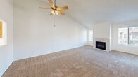 Located at 1325 E Foxhill Dr in Fresno, CA, this single-story, 3-bedroom, 2-bathroom home offers a well-organized layout designed for comfortable everyday living. The living room is a welcoming, carpeted space anchored by a tile-surround fireplace and filled with natural light from a sliding glass door that opens to a private balcony with outdoor views. The kitchen features warm honey-oak cabinetry, white appliances including a range, refrigerator, and dishwasher, and tile flooring that ties the space together. A pass-through opening connects the kitchen to the living area, creating an open and functional flow. A central hallway with carpet connects the three bedrooms and two bathrooms, keeping the private areas of the home clearly separated from the main living spaces. The primary bedroom is generously sized with vaulted ceilings, a ceiling fan, and a sliding-door closet. The bathrooms are fitted with oak vanities, tile flooring, and a tub-shower combination with sliding glass doors. A dedicated laundry area accommodates a full-size washer and dryer with built-in shelving above for added storage. Neutral tones and carpet throughout the bedrooms and living areas give the home a clean, move-in-ready appearance.