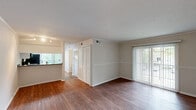 Located at 3030 Spanish Ct in Raleigh, NC, this 2-bedroom, 1-bathroom residence offers a practical and comfortable single-floor layout. The open living area features warm hardwood-style flooring, textured ceilings, and crown molding, with large sliding glass doors that invite natural light and provide views of the surrounding greenery. A wainscoting-style chair rail adds a classic architectural touch throughout the main living space.

The kitchen is equipped with white cabinetry, granite-style countertops, and black appliances including a gas range, microwave, refrigerator, and dishwasher. A sliding glass door directly off the kitchen leads to a private balcony, enhancing the connection to the outdoors.

Both bedrooms are carpeted and feature ceiling fans with integrated lighting and windows with blinds that allow for natural light. The primary bedroom includes access to a generously sized walk-in closet outfitted with built-in shelving and wire rack systems, offering ample storage. A second closet provides additional storage space accessible from the hallway.

The full bathroom features a tub-shower combination, hardwood-style flooring, and clean, neutral finishes. A connecting hallway links the bedrooms, bathroom, and closets, creating an efficient and well-organized floor plan throughout.