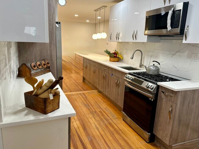 Cocina recién reformada con electrodomésticos de acero inoxidable, suelos de madera originales y amplio espacio de almacenamiento. - 328 High St