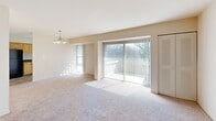 This three-bedroom, one-bathroom apartment at 919 Cloister Rd in Wilmington, Delaware offers a comfortable, single-floor layout with a practical and functional design throughout. The living area is bright and welcoming, featuring plush wall-to-wall carpeting, a chandelier overhead, and an expansive sliding glass door that floods the space with natural light and provides direct access to an outdoor balcony with views of surrounding greenery. A secondary window further enhances the airy atmosphere of the living space. The kitchen is well-appointed with warm light wood cabinetry extending to the ceiling for ample storage, dark granite-style countertops, and a full suite of black appliances including a gas range, dishwasher, refrigerator, and built-in microwave. Tile flooring and a window bring practicality and light to the cooking space. The spacious primary bedroom features soft carpeting and a built-in closet with shelving and hanging rods. The additional bedrooms are similarly carpeted and include closet storage. Neutral tones and clean lines are consistent throughout, creating a cohesive, move-in ready environment suited for comfortable everyday living.