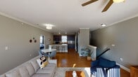 This two-story home offers a thoughtfully designed layout that balances open living spaces with functional private areas. The main level centers around an open-concept living, dining, and kitchen arrangement. The living room is bright and welcoming, featuring crown molding, hardwood-style flooring, a ceiling fan, and a sliding glass door that fills the space with natural light. A compact dining nook sits adjacent to the kitchen, which is well-equipped with rich dark cabinetry, granite countertops, a subway tile backsplash, black appliances including a refrigerator and range, and a breakfast bar with seating. Crown molding carries throughout the main level, adding a refined touch to the neutral gray walls.

The bedrooms are carpeted and comfortably sized, each benefiting from natural light through large windows with blinds. The primary bedroom is served by an en-suite bathroom featuring a double-sink vanity with granite countertops, dark wood cabinetry, a framed mirror, and a separate glass-enclosed shower. A secondary full bathroom includes a tub-shower combo. The dedicated laundry room is a practical highlight, offering built-in shelving, a window, and space for a full-size washer and dryer. Overall, the home presents a clean, modern aesthetic with consistent finishes throughout.