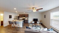 This single-floor residence offers a thoughtfully designed open-concept layout that seamlessly connects the living area and kitchen. The living room features durable wood-look flooring, a ceiling fan with integrated lighting, recessed lighting, and a window that brings in natural light while providing exterior views. The kitchen is equipped with dark espresso cabinetry, light stone-look countertops, a subway tile backsplash, and a full suite of stainless steel appliances including a refrigerator, electric range, built-in microwave, and dishwasher. A peninsula with seating extends from the kitchen, reinforcing the open flow of the space.

Both bedrooms feature plush carpeting, clean white walls, and ample room for full-sized furnishings. Each is served by its own full bathroom, both finished with wood-look flooring, dark vanity cabinetry, stone-look countertops, and a tub-shower combination. A dedicated laundry room houses a full-sized washer and dryer alongside an on-site water heater, adding notable convenience. Throughout the unit, neutral tones and consistent finishes create a cohesive and functional living environment.