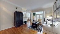 This thoughtfully designed single-floor residence offers a cohesive blend of classic architectural details and comfortable living spaces. Crown molding and warm hardwood flooring flow throughout the main living areas, creating a sense of continuity and elegance.

The spacious living room is a standout feature, anchored by large French doors and expansive windows that flood the space with natural light and provide views of the outdoors. Decorative columns and arched doorways add architectural character, while the open layout allows for versatile furniture arrangements.

The kitchen is outfitted with white raised-panel cabinetry, ample counter space, and hardwood flooring, offering a clean and functional environment. A pantry provides additional storage convenience.

Two well-proportioned bedrooms feature plush carpeting and generous window treatments that allow for natural light while maintaining privacy. Each bedroom is served by its own bathroom. Both bathrooms are finished with neutral tile flooring, wide vanities with white cabinetry, large mirrors, and tub-shower combinations, offering a clean and classic aesthetic throughout.