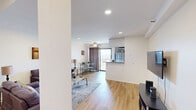 This 520 square foot apartment, located at 7205 Hollywood Blvd, offers a thoughtfully designed living space in the heart of Los Angeles. The single-floor layout maximizes efficiency, featuring one living room and two bathrooms. The living area is the focal point, boasting hardwood floors, recessed lighting, and a ceiling fan for comfort. A purple sofa anchors the space, complemented by a glass coffee table and area rug. Modern artwork adorns the walls, adding visual interest.

The kitchen, while compact, is integrated seamlessly with the living space, featuring modern appliances and cabinetry. A small dining area with a glass table and chairs sits adjacent to the living room, perfect for casual meals or work sessions. Large windows allow natural light to flood the space, creating an open and airy atmosphere.

The apartment includes two bathrooms, both finished with the same hardwood flooring found throughout the unit. They feature clean, white fixtures and modern amenities. A dedicated closet space offers practical storage solutions with built-in shelving and hanging rods. Despite its modest size, this apartment maximizes every square foot, creating a functional and stylish living environment in a prime Hollywood location.