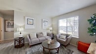 This single-floor residence offers a well-organized layout that balances functionality and comfort throughout its thoughtfully designed spaces. The living room serves as the heart of the unit, featuring wood-style flooring, neutral walls, and a large window fitted with blinds that allow for adjustable natural light and outdoor views. The open, airy atmosphere is well-suited for both relaxing and entertaining.

The galley-style kitchen is efficiently designed with dual-sided cabinetry finished in gray with matte black hardware, light quartz-style countertops, a tile backsplash, and stainless appliances including an electric range and dishwasher. Track lighting overhead illuminates the full length of the space. Adjacent to the kitchen, a dedicated dining area features wood-style flooring, a modern ring pendant light, and framed wall art, creating an intimate setting for meals.

The bedroom is carpeted and generously sized, with a large window providing natural light. A spacious walk-in closet with dual clothing rods offers substantial storage. The bathroom includes a full-size soaking tub with an overhead shower. Throughout the residence, a cohesive neutral palette and consistent finishes contribute to a clean, contemporary aesthetic.