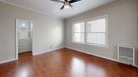 Located at 1412 N Kingsley Dr in the heart of Los Angeles, CA, this efficiently designed single-floor unit offers a thoughtful layout across its compact footprint. The living room is a bright, inviting space featuring rich hardwood flooring, crown molding, neutral gray walls, and a ceiling fan. Natural light streams in through double-pane windows dressed with blinds, creating a warm and airy atmosphere.

The combined dining and kitchen area is a functional highlight of the unit. The kitchen is outfitted with crisp white shaker cabinetry accented by gold hardware, dark countertops, a striking black-and-white patterned tile backsplash, and a full suite of stainless steel appliances including a refrigerator, gas range, and microwave. Light wood-style flooring flows through this area, complementing a charming built-in wall niche that adds a touch of character.

The bathroom is clean and modern, finished in an all-white palette with a vanity featuring white cabinetry, a tub/shower combination, and a window for natural ventilation. Two closets provide practical storage throughout the unit. The overall ambiance is light, neutral, and move-in ready, making this Los Feliz-area unit a well-appointed urban retreat.