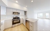 Located in the heart of downtown Edmonton at 104 Street NW, this thoughtfully designed 2-bedroom, 2-bathroom unit offers a clean, modern aesthetic throughout. Light wood-tone flooring flows seamlessly across the entire space, complemented by crisp white walls and an abundance of natural light.

The kitchen is a standout feature, equipped with stainless steel appliances including a refrigerator, electric range, built-in microwave, and dishwasher. White cabinetry with gold-toned hardware pairs with quartz countertops and a marble-style tile backsplash. A generous island with an integrated sink provides additional prep space and casual seating.

The open-concept living area extends from the kitchen toward large windows that frame elevated city views, filling the space with natural light. Both bedrooms are well-proportioned, with the primary bedroom offering direct access to one of the two full bathrooms. Each bedroom benefits from windows with expansive city vistas.

Both bathrooms feature consistent modern finishes, including grey square-tile surrounds over soaker tubs, white floating vanities with quartz countertops, and light wood flooring. Additional conveniences include in-unit laundry, two closets, and a dedicated entrance, making this a fully functional and well-appointed urban residence.