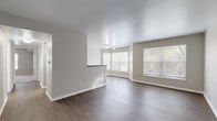 Located at 2600 Harrison St in Kansas City, MO, this single-floor residence offers 2 bedrooms and 3 bathrooms across a well-organized layout. The open-concept living, dining, and kitchen area serves as the heart of the home, featuring rich hardwood-style flooring and multiple large windows — including a charming bay window — that flood the space with natural light and views of mature surrounding trees. The galley-style kitchen is equipped with warm oak cabinetry, dark granite-style countertops, a double sink, and stainless steel appliances, including a range, dishwasher, and refrigerator. A peninsula counter connects the kitchen to the main living area, enhancing the open flow. Both bedrooms are carpeted and generously sized, offering natural light through well-placed windows. The primary bedroom includes direct access to an en-suite bathroom, providing added privacy and convenience. Three closets are distributed throughout the unit, offering ample storage. The bathrooms feature tile flooring with warm earth tones and wood-toned vanities. Additional functional spaces include an entrance, hallway, and a dedicated utility room, rounding out this practical and comfortable Kansas City residence.