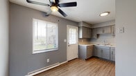 Located at 3058 Allegheny Ave in Columbus, Ohio, this two-story home offers a clean, modern aesthetic throughout, characterized by a consistent cool gray color palette, white trim, and wood-look flooring on the main level. The open main floor living area is bright and welcoming, featuring a staircase with a sleek black metal railing that leads to the upper level. A front-facing window allows natural light to fill the space. The kitchen is well-appointed with gray shaker-style cabinetry, light granite-look countertops, a stainless steel range, refrigerator, and an under-cabinet range hood. A ceiling fan with a light fixture and a back door with an adjacent window add functionality and airflow to the kitchen area. A dedicated laundry room on the main level includes washer/dryer hookups, upper cabinetry, and an electrical panel. Upstairs, the carpeted bedrooms are spacious and well-lit, each equipped with ceiling fans and multiple windows fitted with blinds. The full bathroom features a tub-shower combination with tile surround, wood-look flooring, and a white vanity with cabinet storage. This home provides a practical and comfortable layout suited for everyday living.