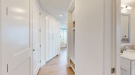 Located in the heart of downtown Austin, this thoughtfully designed two-bedroom, two-bathroom residence offers a refined urban living experience. Floor-to-ceiling windows flood the open living area with natural light while framing dramatic panoramic views of the city skyline. The living room is an inviting, light-filled space with light hardwood flooring that flows throughout the unit. The kitchen features white shaker cabinetry, a white quartz waterfall island with built-in shelving, subway tile backsplash, and stainless steel appliances, seamlessly connecting to the main living area. The primary bedroom is a serene retreat with expansive glass walls, direct balcony access, and sweeping skyline views. Its en-suite bathroom is elegantly appointed with large-format marble-style tile, a dual-sink white vanity, a soaking tub, and a separate glass-enclosed shower. The second bedroom also benefits from floor-to-ceiling windows and city views, with an adjacent bathroom featuring a glass-enclosed shower and white cabinetry. The hallway offers generous built-in storage with full-height cabinetry and open shelving. Two dedicated closets provide ample storage throughout this well-appointed downtown residence.