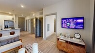 Located at 5025 Wembley Central Ln. in Charlotte, NC, this well-appointed 2-bedroom, 3-bathroom residence offers a thoughtfully designed single-floor layout with modern finishes throughout. The kitchen serves as a centerpiece, featuring a granite-topped island with pendant lighting, white shaker cabinetry, a subway tile backsplash, and stainless steel appliances including a French door refrigerator, range, and microwave. Light wood-look flooring flows through the kitchen and living areas, adding warmth and continuity. The living room is bathed in natural light from floor-to-ceiling sliding glass doors and offers a welcoming, open atmosphere. A hallway with light wood flooring connects the main living spaces to both bedrooms, each fitted with plush carpet, ceiling fans, and large windows. The primary bedroom features an accent brick wall and ample natural light. Both bedrooms include dedicated closets. The bathrooms are finished with granite countertops, light wood cabinetry, undermount sinks, and clean tile flooring. One bathroom includes a full soaking tub with shower combination. With two closets, recessed lighting, and contemporary gray interior doors throughout, this residence balances comfort and modern style in a functional floor plan.