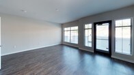Located at 912 3rd Avenue in Chula Vista, California, this well-appointed single-floor unit offers a thoughtfully designed open-concept layout with contemporary finishes throughout. Rich, dark hardwood-style flooring runs through the main living areas, complementing the neutral-toned walls and clean white trim for a cohesive, modern aesthetic.

The living area is bright and generously sized, featuring large windows and glass doors that invite abundant natural light and provide direct outdoor access. Track lighting adds a refined touch to the space. The kitchen is a standout feature, showcasing white upper cabinetry paired with gray lower cabinets, white quartz countertops, and a full suite of stainless steel appliances including a range, microwave, dishwasher, and refrigerator — all centered around a functional island.

The bedrooms are carpeted for comfort, with one featuring a walk-in closet and an en-suite bathroom, offering added privacy. A second bedroom provides a window with natural light. The bathroom is finished with tile flooring, a gray vanity with a white countertop, a large mirror, and a full soaking tub with a subway tile surround. Additional storage closets are integrated throughout the unit, enhancing everyday practicality.