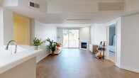 Located in the heart of Marina del Rey, this well-designed 3-bedroom, 2-bathroom residence offers a thoughtfully laid-out single-floor plan with a clean, modern aesthetic throughout. The bright living room serves as the centerpiece of the home, featuring wood-style flooring, a corner fireplace with a white surround, and a sliding glass door that opens to a private balcony. From the balcony, sweeping views of mature trees, palm-lined streets, and marina boat slips create a distinctly coastal ambiance. The adjacent dining area benefits from natural light and is accented by a ceiling fan overhead. The kitchen is equipped with light wood cabinetry, ample upper and lower storage, white appliances, and a peninsula counter that connects it to the dining space. The generously sized primary bedroom features plush carpeting and access to a spacious walk-in closet with multi-tiered wire shelving systems. The primary bathroom includes a soaking tub, a wood-toned vanity with a white countertop, and clean, light flooring. Two additional bedrooms offer carpeted floors, natural light, and versatile layouts. A second full bathroom serves the remaining bedrooms. Throughout the residence, bright white walls and consistent finishes create a cohesive, airy feel well-suited to the Southern California lifestyle.