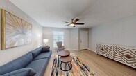 This two-floor residence offers a thoughtfully designed layout with a blend of modern finishes and functional living spaces. The living room serves as the heart of the home, featuring light hardwood flooring, a ceiling fan, and natural light streaming through blinds-covered windows. The open, airy atmosphere is complemented by neutral gray walls and clean white trim throughout.

The kitchen is outfitted with crisp white shaker-style cabinetry, granite countertops, black appliances including a refrigerator and range, and a peninsula with an undermount sink — providing both workspace and a casual gathering point. Adjacent to the kitchen, the dining area accommodates a glass-top table and offers natural light from a window with blinds, creating a pleasant space for everyday meals.

The bedrooms feature plush carpet flooring, ceiling fans, and generous closet space with multiple built-in storage options. The bathrooms echo the kitchen's design language, with white vanity cabinetry, granite countertops, and well-lit mirrors.

Throughout the residence, a consistent palette of soft grays and whites creates a cohesive, modern aesthetic. The combination of hardwood-style flooring in common areas and carpet in bedrooms adds both practicality and comfort, making this a versatile and move-in-ready home.