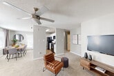 This single-floor, 2-bedroom, 2-bathroom home in Baton Rouge, Louisiana offers a functional and comfortable layout designed to maximize every square foot. The open-concept living area is anchored by plush carpet flooring and a ceiling fan, creating a relaxed atmosphere. Natural light filters through windows dressed with blinds and curtain panels, brightening the neutral gray-toned walls throughout. The living room flows seamlessly into the dining area, which features a dedicated window for additional light, and connects to a galley-style kitchen outfitted with white shaker cabinetry, granite countertops, a subway tile backsplash, hardwood-style flooring, and black appliances including a gas range, microwave, dishwasher, and refrigerator. Both bedrooms are carpeted and include ceiling fans and closets. The primary bedroom offers a comfortable, private retreat, while the second bedroom provides versatile space. Each bathroom is clean and functional, with a tub-shower combination. A hallway connects the bedrooms and bathrooms, maintaining a practical flow throughout. With two closets and a well-organized layout, this home provides efficient storage and livable comfort in a convenient Baton Rouge location.