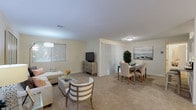 This single-floor residence offers a thoughtfully designed layout that balances comfort and functionality across its key living spaces. The open-concept living and dining area forms the heart of the home, finished with plush wall-to-wall carpeting and warm cream-toned walls that create a bright, welcoming atmosphere. Large windows with blinds allow generous natural light to fill the space, while a dedicated dining area with a folding partition provides optional separation from the living room. The galley-style kitchen is efficiently arranged with white cabinetry, tile flooring, ample counter space, and stainless steel appliances including a gas range and refrigerator. Two well-sized bedrooms are carpeted and finished in soft neutral tones, each featuring closet storage. The primary bedroom benefits from a window overlooking lush greenery, adding a serene natural backdrop. A mirrored dresser and organized closet add to the room's practicality. The full bathroom includes a clean white vanity with an integrated sink and a large wall mirror. Additional storage is available throughout the unit, including a dedicated walk-in storage area ideal for seasonal items and gear. The overall ambiance is calm and cohesive, with a neutral palette that lends itself well to a variety of interior styles.