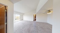 Located at Cambridge Club Circle in Ann Arbor, Michigan, this single-floor, 2-bedroom, 2-bathroom residence offers a well-organized layout designed for comfortable everyday living. The spacious living room is an immediate standout, featuring soaring vaulted ceilings that create an open, airy atmosphere. Soft carpeting extends throughout the living area and bedrooms, while a sliding glass door floods the space with natural light and provides direct access to a private outdoor balcony with views of surrounding greenery. A ceiling fan adds to the comfort of the living space. The primary bedroom is generously sized, offering ample room for large furnishings, with a window dressed in vertical blinds that allow for natural light control. The second bedroom is similarly well-proportioned, also featuring carpet and a bright window. Both bathrooms are clean and functional, each equipped with a vanity, large mirror, and updated fixtures; the full bathroom includes a shower-tub combination. A dedicated laundry area houses a stacked washer and dryer unit alongside a water heater and HVAC system, adding in-unit convenience. Hallways connect the rooms efficiently, and a closet provides additional storage. The overall ambiance is bright, neutral, and move-in ready.