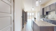 This contemporary one-bedroom apartment at The Flats at Palisades optimizes its 540 square feet with a thoughtful, open-concept design. The heart of the home is a sleek, gourmet kitchen featuring dark wood cabinetry, stainless steel appliances, and a stylish glass tile backsplash. A central island with a quartz countertop provides additional workspace and casual dining options.

The living area seamlessly connects to the kitchen, creating an expansive feel enhanced by wood-style flooring throughout. Large windows flood the space with natural light, while offering city views. The bedroom, measuring 110 square feet, includes plush carpeting and a generous window for a bright, airy ambiance.

A well-appointed bathroom showcases modern fixtures, a granite vanity, and ceramic tile flooring. Two closets offer ample storage space. The apartment's clean lines, neutral color palette, and high ceilings contribute to its modern aesthetic. Strategically placed recessed lighting and pendant fixtures provide both ambiance and functionality, completing this urban retreat designed for comfortable, stylish living.
