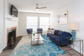 Located at 5050 Tanglewood Ln in Odessa, Texas, this single-floor residence offers a thoughtfully laid-out living space with modern updates throughout. The living room serves as a comfortable centerpiece, featuring wood-look flooring, a ceiling fan, a textured ceiling, and large windows fitted with white blinds that invite generous natural light. The open flow connects seamlessly to the dining area, which features the same warm flooring and direct sightlines into the kitchen, making the space feel cohesive and functional. The galley-style kitchen is well-equipped with white cabinetry, marble-look countertops, black appliances including a range and full-size refrigerator, a deep single-basin sink with a matte black faucet, and a subway tile backsplash. The bedroom is carpeted and serene, with a ceiling fan, a window with blinds, and a textured ceiling that echoes the rest of the home. The bathroom is clean and updated, offering a vanity with marble-look countertop, matte black hardware, a large mirror, wood-look flooring, and a shower-tub combo with a classic white curtain. Throughout the residence, a neutral color palette and consistent finishes create a cohesive, move-in-ready atmosphere.