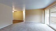 Located at 401 N Thompson Dr in Madison, Wisconsin, this single-floor unit offers a well-organized layout with a practical mix of flooring, finishes, and functional living spaces throughout. The open living and dining areas are finished with neutral-toned carpet and warm beige walls, with a ceiling fan providing comfort overhead. A sliding glass door leads directly to a private outdoor balcony, bringing in natural light and views of surrounding greenery. A wall-mounted air conditioning unit and baseboard heating ensure year-round climate control. The galley-style kitchen features warm wood cabinetry, dark granite-style countertops, a stainless steel refrigerator, dishwasher, and a double sink, all set over durable hardwood-style flooring. The bedrooms are carpeted and bright, each benefiting from natural light through windows overlooking outdoor greenery. The bedrooms include closets with built-in rods for storage, and baseboard heating keeps each room comfortable. The full bathroom is appointed with a wood-toned vanity, white countertop, a tub-shower combination, and hardwood-style flooring. The entry area features hardwood-style flooring and a coat closet, providing a clean and practical transition into the living space.