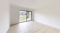 Located in Hialeah, FL, this single-floor, one-bedroom, one-bathroom unit offers a clean and functional layout across a compact but well-organized floor plan. Light-toned ceramic tile flooring runs consistently throughout the entire space, lending a cohesive and easy-to-maintain aesthetic.

The living room is a bright, open area highlighted by a large sliding glass door that frames views of a green outdoor area with mature trees, allowing natural light to flood the interior. Adjacent to the living room, the dining area provides a defined space for everyday meals. A structural beam detail subtly separates these zones while maintaining an open feel.

The kitchen is efficiently designed with white cabinetry, a marble-patterned countertop, a coil-burner electric range, and an overhead range hood. A window above the counter brings in additional natural light and outdoor views.

The bedroom is a comfortable, well-proportioned room with crisp white walls and a window overlooking the exterior greenery, offering a calm and airy atmosphere. A dedicated closet provides practical storage.

The bathroom includes a full tub-shower combination with warm-toned tile surround, a vanity with a granite-style countertop, and tile flooring. A separate door within the bathroom provides added privacy and storage access. The overall unit maintains a clean, neutral palette throughout.