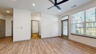 Located at 101 Dean Ave in Raymore, Missouri, this single-story, one-bedroom, one-bathroom unit offers a thoughtfully designed modern layout across a generous floor plan. Warm wood-look luxury vinyl flooring runs consistently throughout every room, creating a cohesive and clean aesthetic.

The open-concept kitchen and living area serves as the heart of the home. The kitchen is equipped with stainless steel appliances — including a refrigerator with ice maker, range, and over-the-range microwave — complemented by light wood cabinetry, a white subway tile backsplash, and a large peninsula with a gray countertop and integrated sink. Recessed lighting illuminates the space efficiently.

The living area is spacious and airy, featuring a ceiling fan, recessed lighting, and large windows dressed with horizontal blinds that invite ample natural light. A glass-panel entry door with transom window adds an architectural touch and connects to the outdoor surroundings.

The bedroom is well-sized, offering a ceiling fan, a large window with outdoor views, and a double-door closet for generous storage. The bathroom continues the modern design language with light wood cabinetry, a gray countertop vanity, an undermount sink, wall-mounted storage cabinet, and matching wood-look flooring throughout.