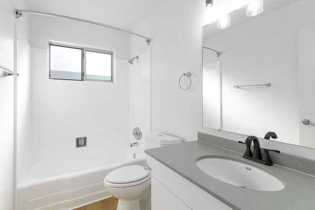 Hall bath with tub and shower combo and vanity for storage - Skylar Apartments