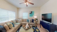 Located at 2416 W Saint Petes Ct in Fayetteville, Arkansas, this single-story residence offers a well-organized layout with distinct living, kitchen, sleeping, and bathroom areas. The living room serves as the central gathering space, featuring a ceiling fan with light fixture, soft carpeting, and multiple windows fitted with blinds that allow generous natural light to fill the room. The open, comfortable feel is enhanced by neutral wall tones throughout.

The kitchen is equipped with white cabinetry, dark countertops, tile flooring, and a full suite of white appliances including a range, microwave, and refrigerator. A pass-through window connects the kitchen to adjacent areas, and space for a dining table is conveniently situated nearby.

The bedrooms are carpeted and each includes a window for natural light, ceiling fans for ventilation, and ample wall space. The rooms maintain a calm, neutral palette that contributes to a restful atmosphere.

Two bathrooms are present, each featuring a tub and shower combination with sliding glass doors, tile flooring, a vanity with storage cabinetry, and a mirror. The overall layout is functional and efficiently designed, making practical use of the available single-floor footprint.