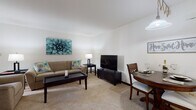 Located at 9056 W Waterford Square S in Greenfield, Wisconsin, this single-floor residence offers a thoughtfully arranged layout designed for comfortable everyday living. The open living and dining area is carpeted throughout and filled with natural light from a large sliding glass door that opens to an outdoor view, creating a bright and welcoming atmosphere. The space flows naturally between a seating area and a dining nook, making it ideal for both relaxing and entertaining.

The kitchen features warm oak cabinetry with ample upper and lower storage, white countertops, a double-basin sink, and tile flooring. A laundry area is conveniently accessible directly from the kitchen, adding practical functionality to the space.

The bedroom is generously sized, featuring soft carpet, a teal accent wall, and a wide sliding-door closet that provides substantial storage. A cozy sitting nook within the bedroom offers a quiet retreat, complete with natural light from a large window.

The bathroom is clean and functional, featuring a full vanity with oak cabinetry, a framed mirror, and a tiled tub-shower combination equipped with a safety grab bar. The overall design of this residence combines practical features with a warm, comfortable ambiance suited for single-level living.